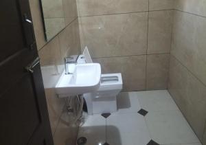 un baño con lavabo e inodoro en All Seasons Guest House, en Trivandrum