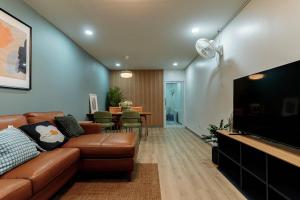 a living room with a couch and a flat screen tv at Cozy Nest Ladprao - 3BR Townhome 3min walk from MRT in Bangkok
