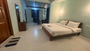 a bedroom with a bed and a living room at Riwai Root Bridge homestay in Mawlynnong