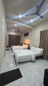 a bedroom with two beds and a ceiling fan at Riwai Root Bridge homestay in Mawlynnong