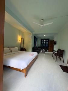 a bedroom with a large bed and a living room at Riwai Root Bridge homestay in Mawlynnong
