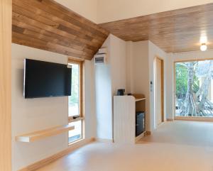 a living room with a flat screen tv on the wall at rimbaymangrove resort in Ban Khlong Tamru