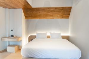 - une chambre avec un lit blanc et un plafond en bois dans l'établissement rimbaymangroveresort, à Ban Khlong Tamru