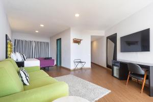 Hotel Eetu Begur, Affiliated by Meliá في بيغور: غرفة معيشة مع أريكة وتلفزيون وسرير