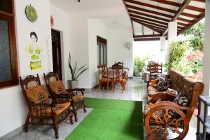 Guesthouse Kind and Love في هيكادوا: غرفة معيشة مع أرضية خضراء وكراسي