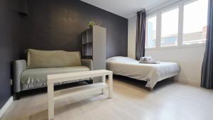 Un dormitorio con una cama, una silla y una mesa. en Intimissime, en Dunkerque