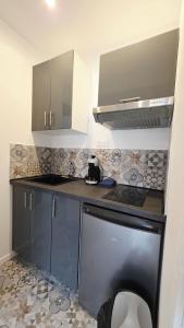 cocina con encimera negra y fogones en Intimissime, en Dunkerque