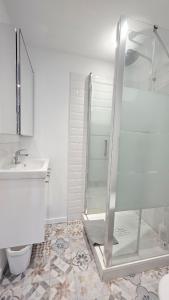 Un baño blanco con ducha y lavabo. en Intimissime, en Dunkerque 25 fotos más