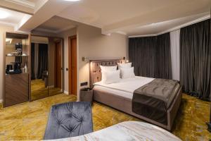 a hotel room with a bed and a chair at Hotel Brilliant Plaza in Zalău
