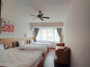 a hotel room with three beds and a ceiling fan at Star Hotel - Khách sạn Ngôi Sao in Tam Ðảo