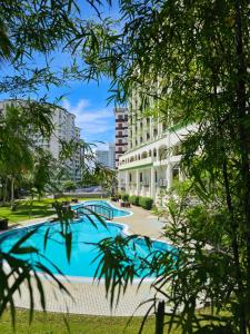 a swimming pool in the middle of a city with buildings at De Greenish Village Langkawi in Kuah +76 photos