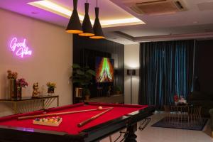 uma mesa de bilhar num quarto com um letreiro de néon em Gold Crest Grand Apartments City View -DHA Phase 4 Lahore em Lahore