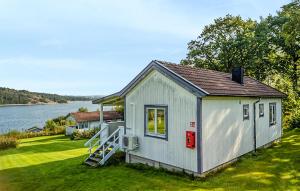 a tiny house on the side of a lake at Lovely Home In Myggenäs With Sauna in Höviksnäs