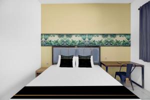 una camera da letto con un letto grande e una scrivania di Hotel O near Trans Studio Theme Park formerly Sunset Cozy Residence a Mantaak