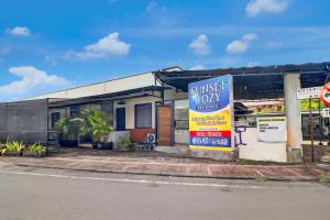 a house with a sign in front of it at Hotel O near Trans Studio Theme Park formerly Sunset Cozy Residence in Mantaak