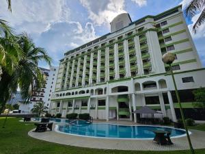 Un gran edificio con una piscina en frente. en De Greenish Village Langkawi, en Kuah