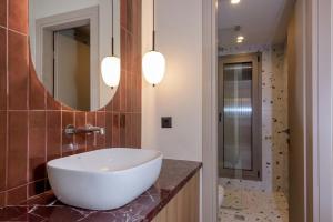 een badkamer met een witte wastafel en een spiegel bij Mavili Urban Elegance in Bendevís