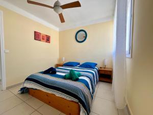 a bedroom with a bed with a green stuffed animal on it at Palhawai - Appartement 2 chambres avec terrasse, parking et vue mer panoramique in Palavas-les-Flots