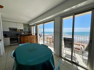 a kitchen with a table and a view of the ocean at Palhawai - Appartement 2 chambres avec terrasse, parking et vue mer panoramique in Palavas-les-Flots