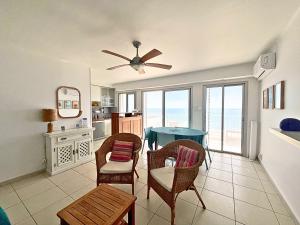 a living room with a table and chairs and the ocean at Palhawai - Appartement 2 chambres avec terrasse, parking et vue mer panoramique in Palavas-les-Flots +16 photos