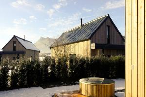 アシャウ・イム・キームガウにあるAgrad Chaletsの雪と山々を背景にした2つの木造納屋