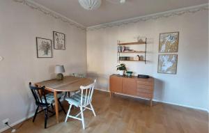 a dining room with a table and chairs and a desk at Nice Home In Bolmsö With Lake View in Bolmsö