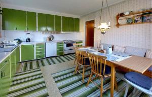 a kitchen with green cabinets and a wooden table at Nice Home In Bolmsö With Lake View in Bolmsö