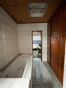 a bathroom with a bath tub and a bedroom at Couba Club in Douala