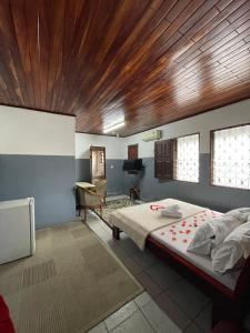 a bedroom with a large bed and a wooden ceiling at Couba Club in Douala