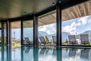een groep stoelen in een zwembad bij Valsana Hotel Arosa - Small Luxury Hotel in Arosa