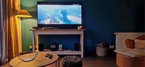 a living room with a flat screen tv on a table at Gîte La Malavisée in Leernes