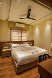 a bedroom with a large bed with a ceiling fan at CaaZa Ventura in Sultan Bathery