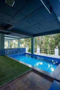 a large swimming pool with a blue ceiling at CaaZa Ventura in Sultan Bathery