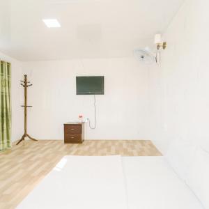 a white room with a tv and a cross on the wall at TRUNG LUONG HOMESTAY in My Tho