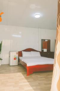 a bedroom with a bed and a small refrigerator at TRUNG LUONG HOMESTAY in My Tho