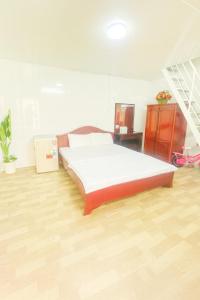 a bedroom with a bed and a wooden floor at TRUNG LUONG HOMESTAY in My Tho