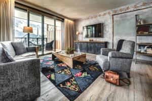 een woonkamer met twee banken en een open haard bij Valsana Hotel Arosa - Small Luxury Hotel in Arosa