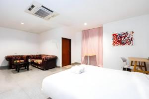 een hotelkamer met een bed en een bank bij XX Mitr INN Sukhumvit Soi 2 in Bang Kapi