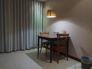 a dining room table with two chairs and a lamp at Townhouse PK Garden in Bangkok