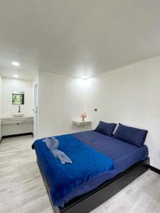 Kohmook Timberland Resort from Seaview في كو موك: غرفة نوم بسرير ازرق عليها دبدوب