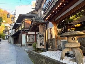 un edificio asiatico con un cappello in cima di Hatsunoyu a Yamanouchi