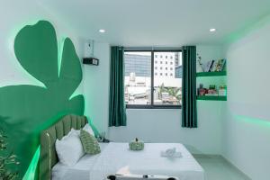 a bedroom with a bed and a window with green curtains at Ori Home in Ho Chi Minh City