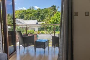 a room with a view of a balcony with chairs and a table at Yvon's Tropical Villa in Grand Anse