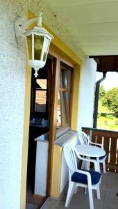 a porch with two chairs and a table and a light at Lohberg Apartment in Lohberg +2 photos