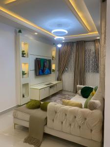 a living room with a couch and a tv at Ozin Retreat And Wellness Home in Ikeja