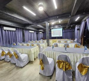 a conference room with tables and chairs and a screen at Maderlar Farm Restaurant & Resort in Ban Kao Lieo