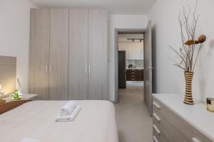 a bedroom with a white bed and a vase of flowers at Elmswater court in St. Paul's Bay