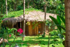 a small hut with a grass roof at Mtoni River Lodge in Arusha