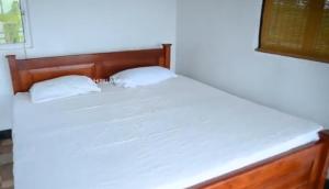 a bed with two white pillows on top of it at Kataragama leopard One Villa Yala in Gotamegama