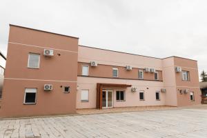 a large building with a brick driveway in front of it at Gallus Inn in Aleksinac